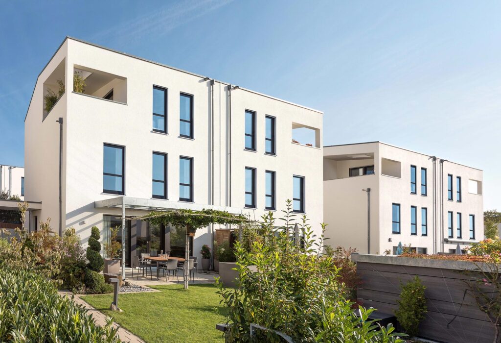 Moderne weiße Doppelhaushälfte mit Flachdach, großen Fenstern, Terrasse und Garten