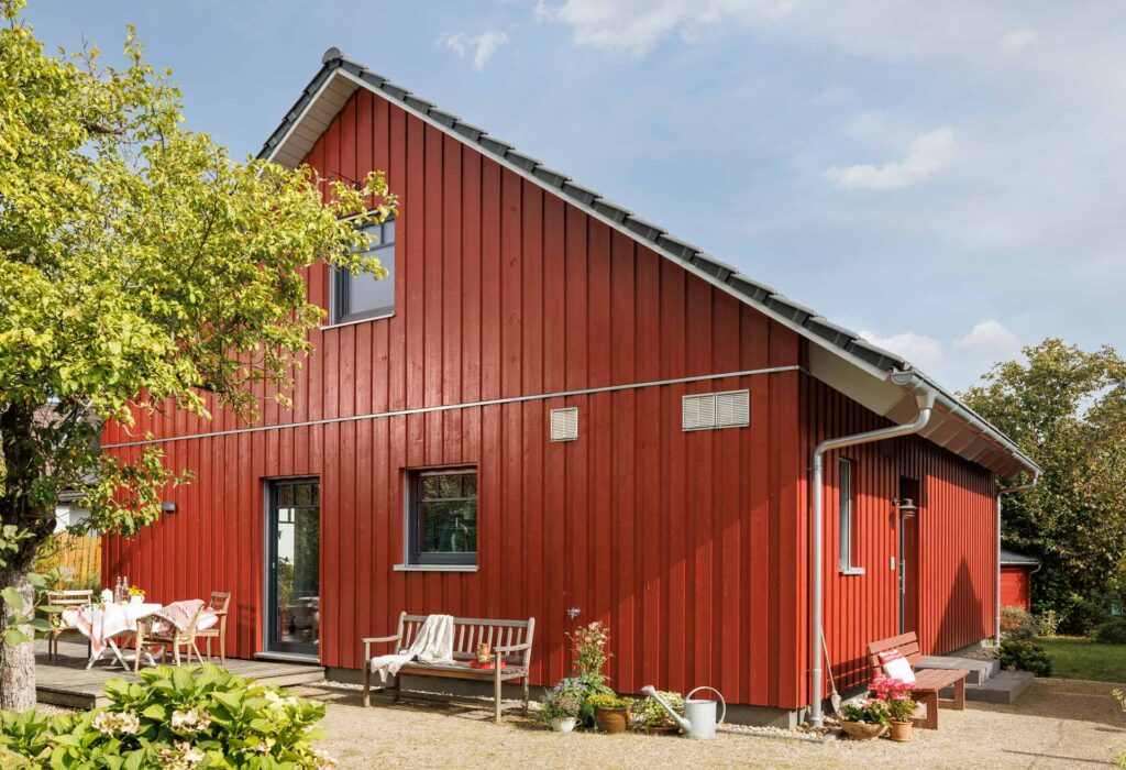 Bungalow mit roter Holzfassade und Satteldach