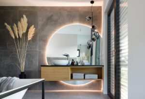 Modernes Badezimmer im Neubau mit großformatigen Fliesen, stilvoller Badkeramik und bodengleicher Dusche – Designideen für die Badgestaltung im Fertighaus.