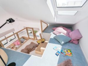 Heller Dachausbau in einem modernen Bungalow mit Galerieebene, offener Holztreppe und großzügiger Raumhöhe – Ideen für flexiblen Wohnraum im Fertighaus.