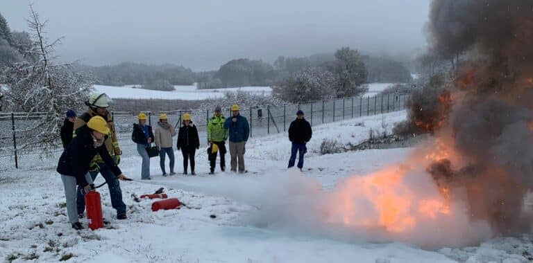 Azubis üben beim Safty@Work-Tag bei SchwörerHaus das Feuerlöschen